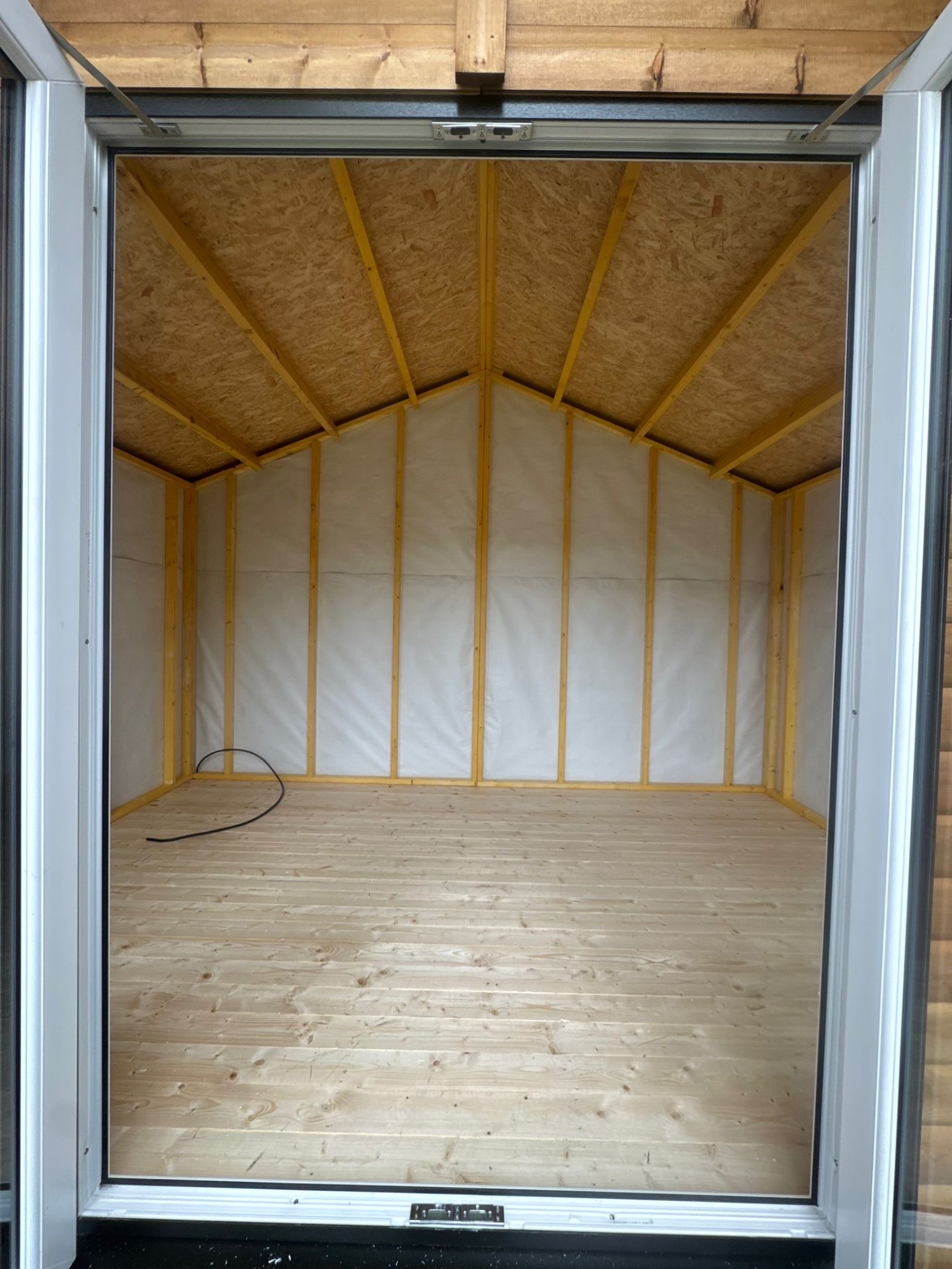 Inside a newly built timber garden room with apex roof and timber floor