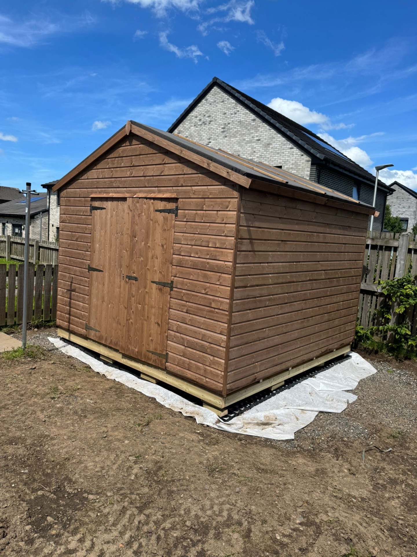 Large timber shed with double doors on a prepared base